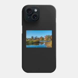 Church standing on the calm lake shore in sunny day Phone Case