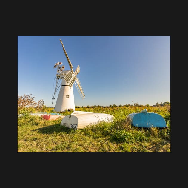 Day boats upside down on the riverbank with Thurne Mill in the background by yackers1