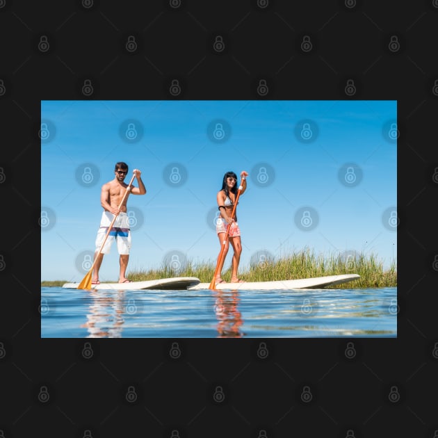 Man and woman stand up paddleboarding by homydesign