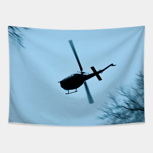 A Bell UH-1 Huey Iroquois flying low over trees Tapestry by Pitmatic