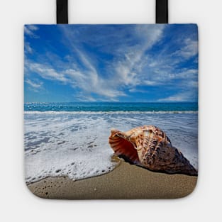 Beach with conch shell under blue sky Tote