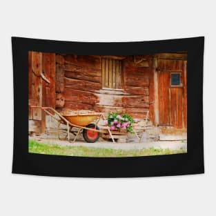 Rusted Wheelbarrow in Front of Wooden Farm House Tapestry