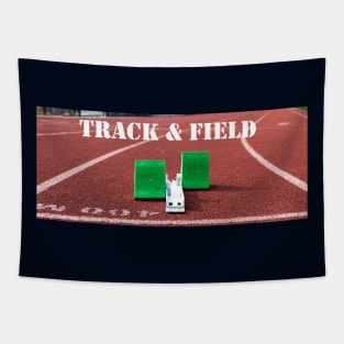 Track and field written above green starting blocks on a red track Tapestry