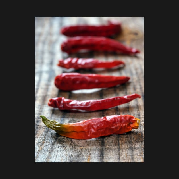 Dried chili peppers on a wooden board by naturalis