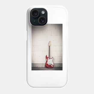 Red electric guitar against white brick wall background Phone Case