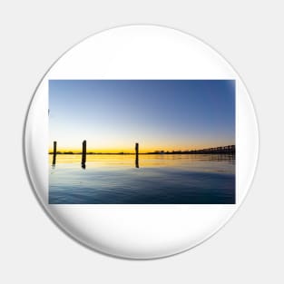 Sweeping lines of Tauranga's historic railway bridge with sunrising on left cast golden hues across harbor Pin