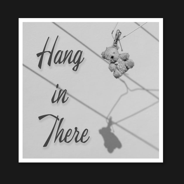 'Hang in There' typography next to a very old tired worn teddy bear hanging out to dry from a coat hanger. by Earthworx