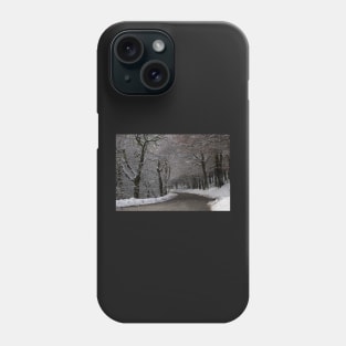 Snow covered woodland tree tunnel over road Phone Case