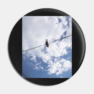 Girl in slingshot against blue cloudy sky Pin