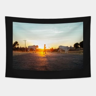 Silhouette of Boy Leading Cattle Across Road at Sunset in Burmese Countryside Tapestry