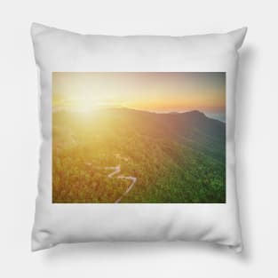 Aerial view of curvy mountain road through a jungle ay sunset Pillow