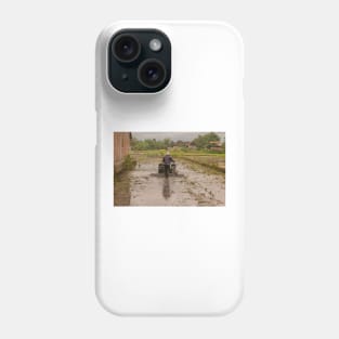 A man in backside view plows a village rice field. Phone Case