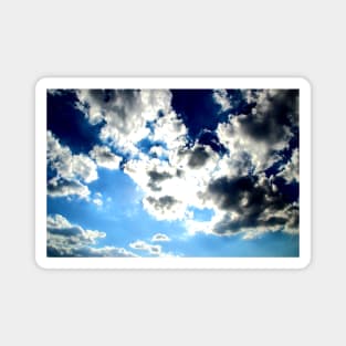 Peaceful scenery with powerful sunbeams making their way through fluffy clouds in the blue sky Magnet