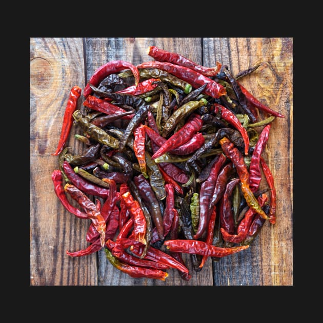 Dried chili peppers on a wooden board by naturalis
