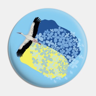 A Stork carries a Ukrainian flag and wildflowers on its wings Pin