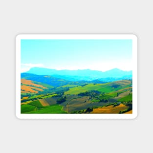 Scenery in Carassai with rolling fields and hazy mountains in the background Magnet