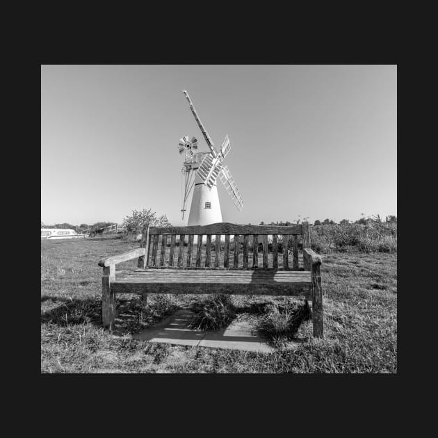 Wooden bench and traditional windmill on the riverbank by yackers1