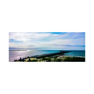 Pier with concrete breakwaters. Seascape, glare on the water of the Baltic Sea, rays of light T-Shirt