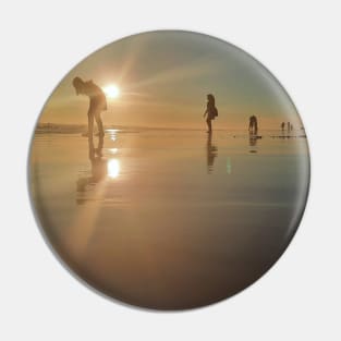 Silhouetted people in a row on a sand beach. Pin