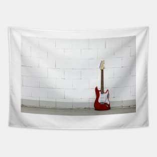 Red electric guitar against white brick wall Tapestry