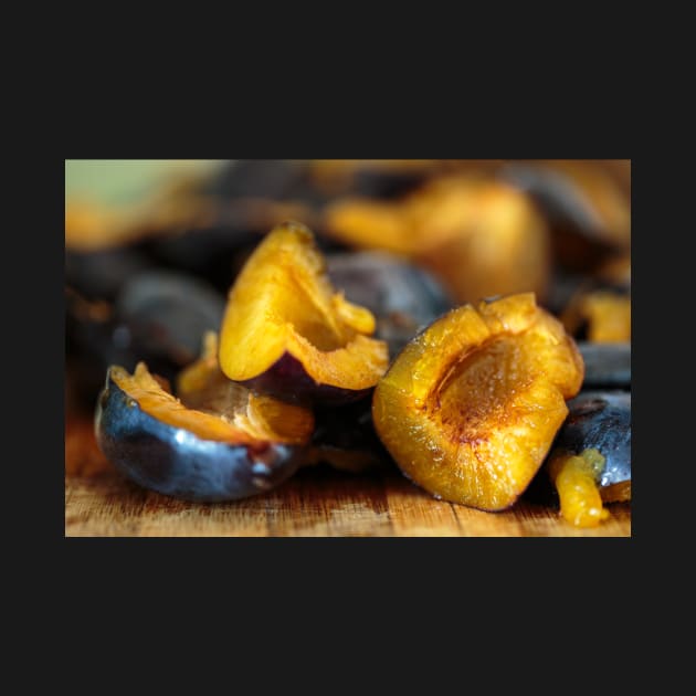 Plums sliced on a wooden board by naturalis