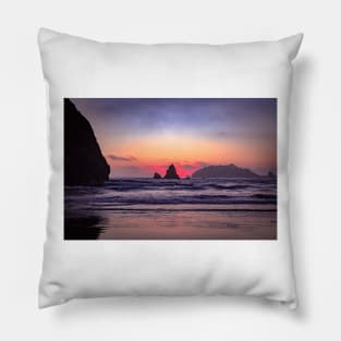 Red sunset behind coastal rock Pillow