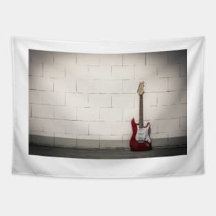 Red electric guitar against white brick wall Tapestry