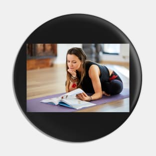 Young woman reading a yoga book Pin