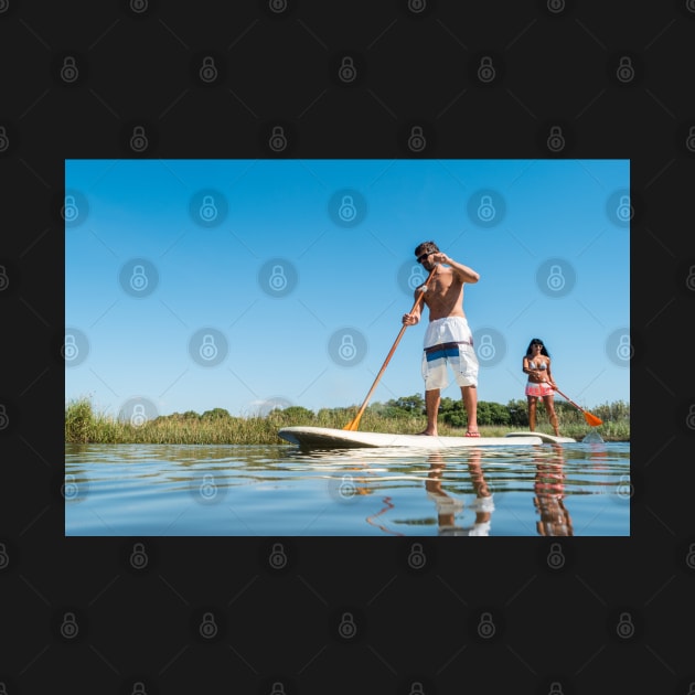 Man and woman stand up paddleboarding by homydesign