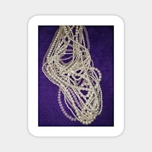 Pearls and beads on a purple background Magnet