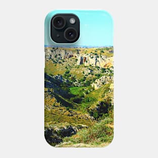 Rocky canyon partly covered with green grass and randomly placed shrubs near Matera Phone Case