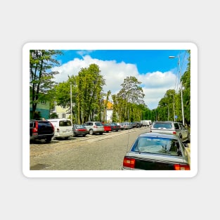 Street of the city. Parked cars. Clear weather. Tram rails Magnet