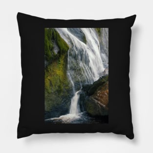 A beautiful waterfall cascades down a mountain in Ireland. Pillow