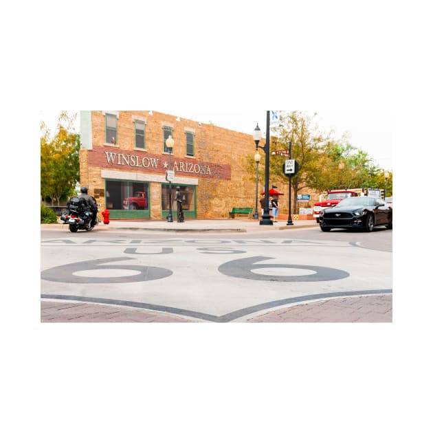 Route 66 sign on road in Winslow Arizona by brians101