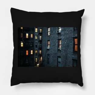 A New York City courtyard with lit windows at dusk Pillow