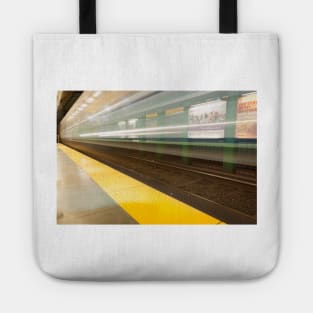 Platform with yellow line railway tracks blurred in motion blur aws train passes. Tote