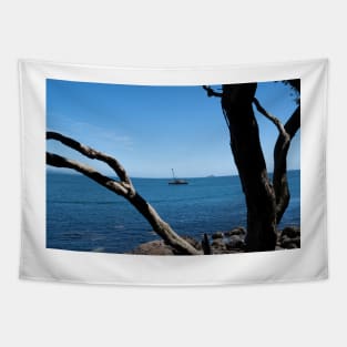 View through twisted pohutukawa tree branches across barge with crane blue ocean to distant horizon Tapestry