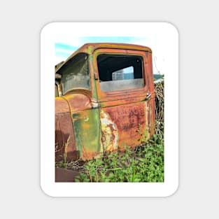 Resting and peacefully rusting in a field Magnet