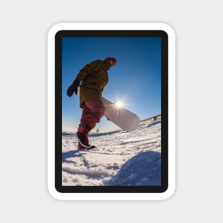 Snowboarder walking against blue sky Magnet