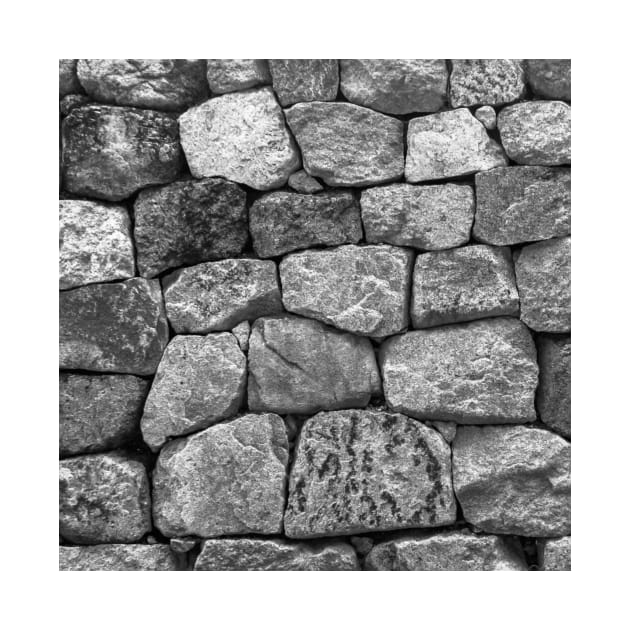 Boulder stone wall in grey and beige stones laid in a random pattern by podartist