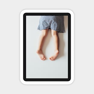 Legs of Small Girl Lying on White Tabletop Magnet