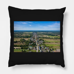 Aerial view of village surrounded by agricultural fields under blue sky Pillow
