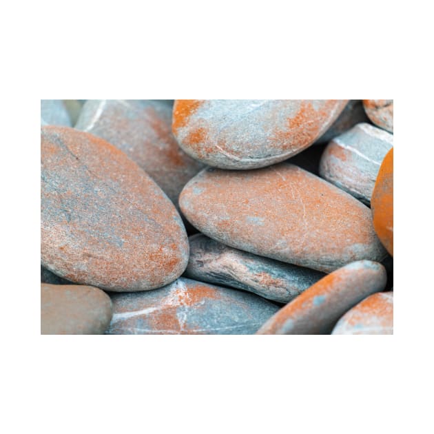 Beach stones in grey with orange coloured lichen growth by brians101