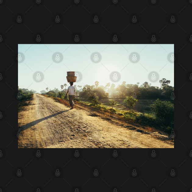 Woman Carrying Baskets on Head Walking in Burmese Countryside in Early Morning by visualspectrum