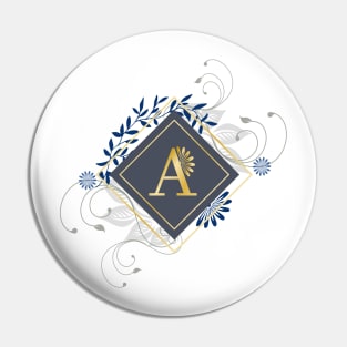 A blue and gold initial monogram. Pin