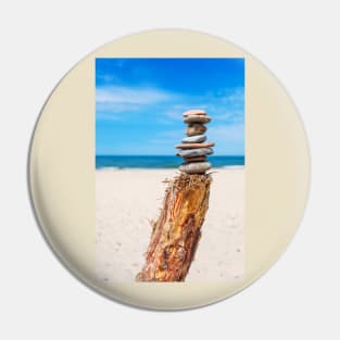 Stack of stones on the beach against blue sky Pin