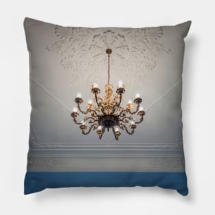 golden chandelier suspended down a ornate ceiling Pillow