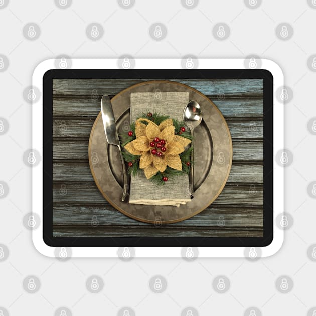 Overhead view of  table setting - a plate with spoon, fork and knife with a Christmas decoration on a wooden background. Magnet by ikshvaku