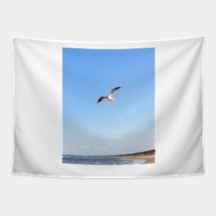 White seagull flying above the seacoast Tapestry