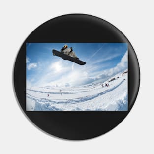 Snowboarder jumping against blue sky Pin